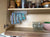 Customer photo — LidLoft 10-Slot organizer holding food-storage lids under a wood cabinet shelf
