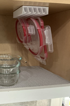 Customer photo — LidLoft 5-Slot organizer holding round red-rimmed lids under a cabinet shelf