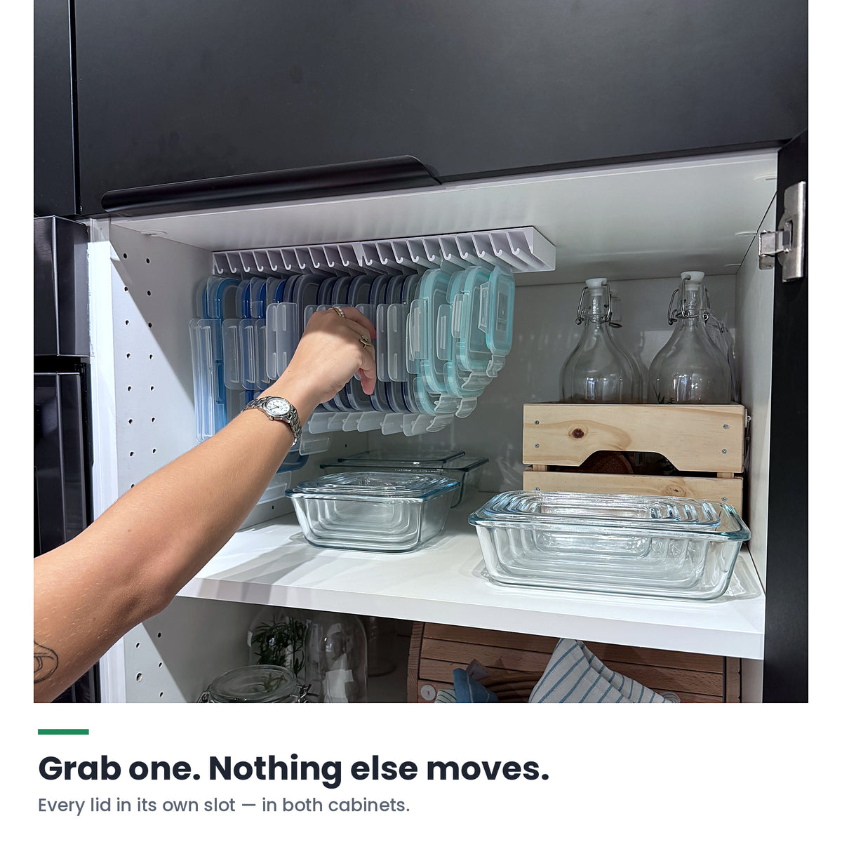 A hand pulling one lid from a LidLoft 2-Pack mounted under a kitchen cabinet shelf — nothing else moves